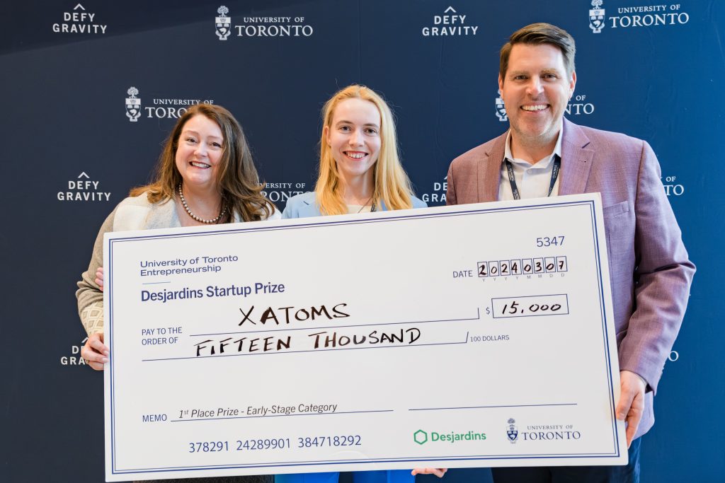 From left to right: Marilyn Horrick, Diana Vigovicova, and Jon French holding a $15,000 cheque, won by Virgovicova, for Xatoms.